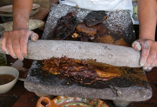 Grinding mole ingredients on a metate